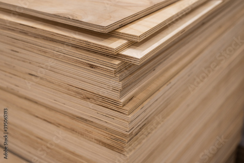 OSB sheets are stacked in a hardware store. The building material is wood.