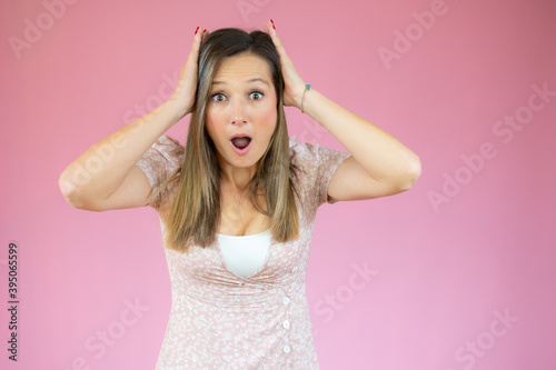 Image of excited screaming shocked beautiful woman standing isolated over pink background.