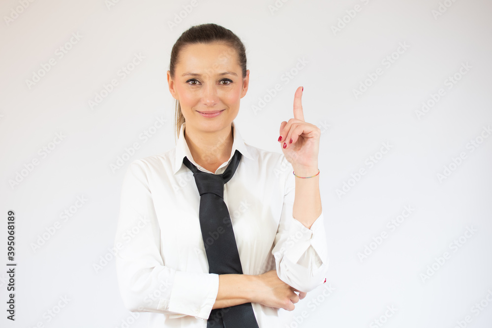 Smiling business woman pointing up and looking at the camera over white background Smiling business woman pointing up and looking at the camera over white background