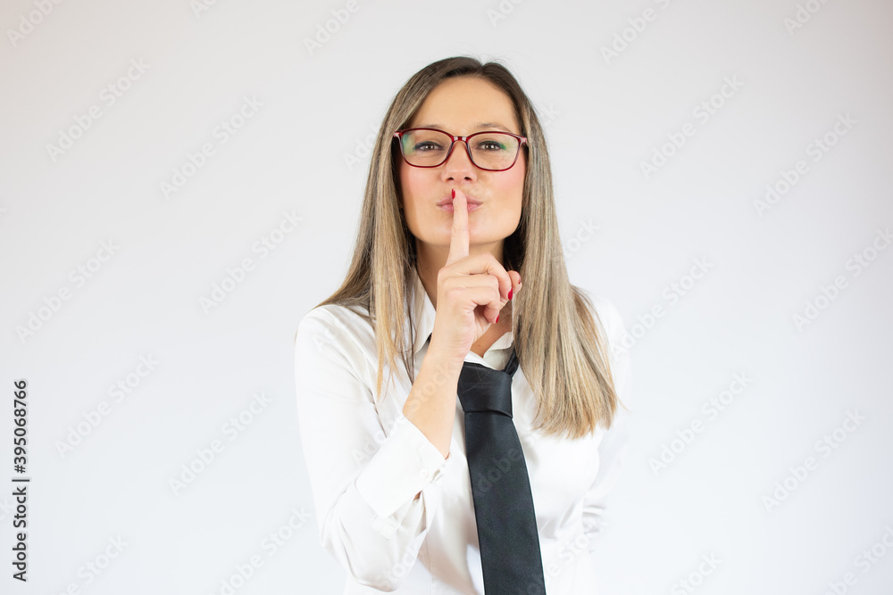 Portrait of a confident young business woman showing silence gesture and looking at camera isolated over white background Portrait of a confident young business woman showing silence gesture and looking at camera isolated over white background