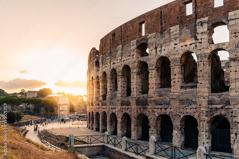 Outdoor view of The Colosseum or Coliseum with sun flare on background, also known as the Flavian Amphitheatre. It is an oval amphitheatre in the centre of Rome.