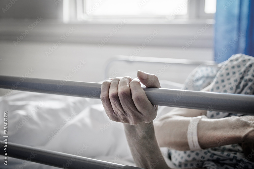 Dłonie starszej osoby na łóżku szpitalnym - obrazy, fototapety, plakaty 