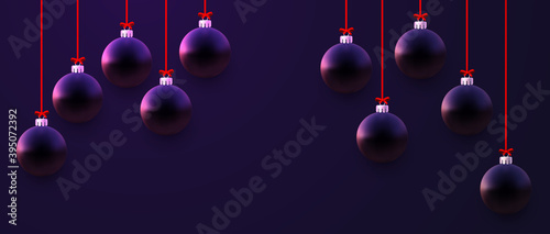 Matt dark violet christmas baubles hanging on ribbons.