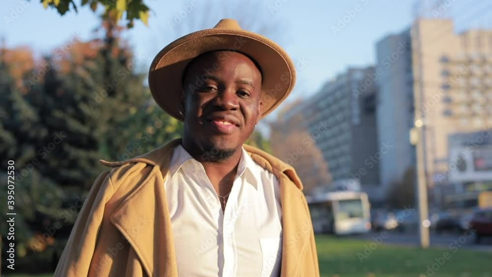 Stylish African-American man posing for camera in city Stylish African-American man posing for camera in city