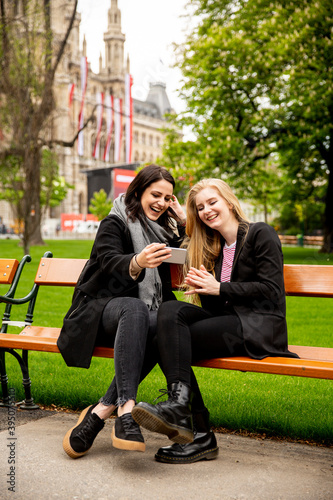 Young female tourists taking selfie with mobile photo in centre of Vienna, Austria