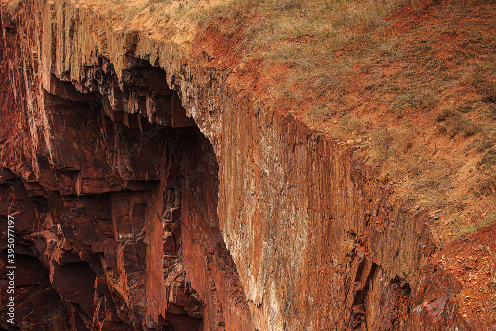 The exit of oxidized iron ore to the surface as a cliff break