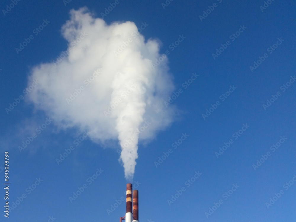 White smoke from the chimney against the blue sky