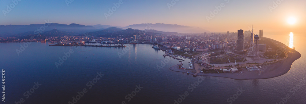 Dramatic Wide HDR aerial panoramic view of Batumi city port and sightseeing attrcation with real estate buildings in the background during the sunset. Georgia travel destination