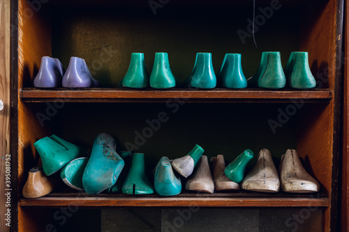 In the workshop in a wooden rack are colored blanks for different shoes.