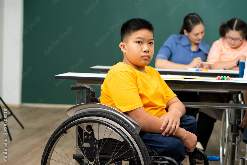 disability boy sitting on wheelchair in classroom special with teacher and AUtism kids education disability boy sitting on wheelchair in classroom special with teacher and AUtism kids education