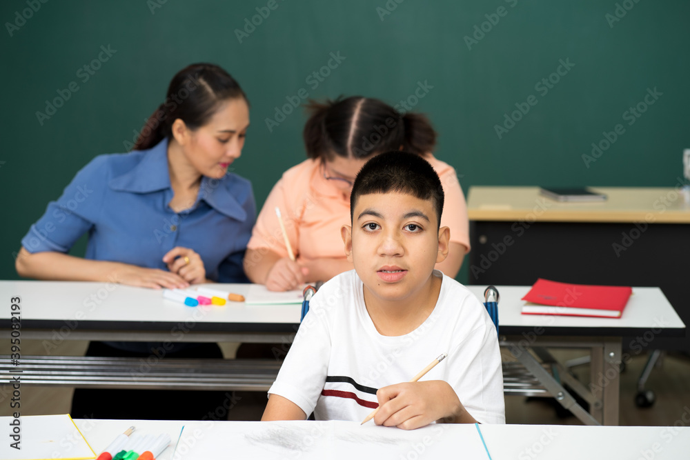 disability boy sitting on wheelchair in classroom special with teacher and AUtism kids education disability boy sitting on wheelchair in classroom special with teacher and AUtism kids education