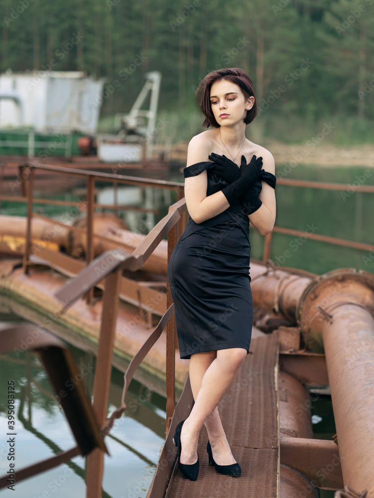 Beautiful girl in a fashionable little stylish black dress. Fashion, beauty and style.
