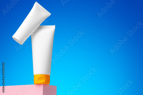 Blank white cosmetic container against blue background