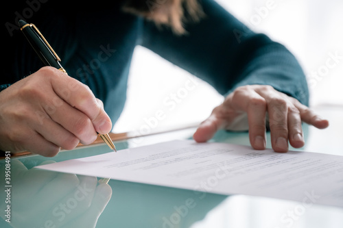 Woman in shirt signing docu