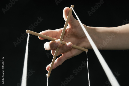 Human hand with cross for controlling a puppet. Concept of control. photo