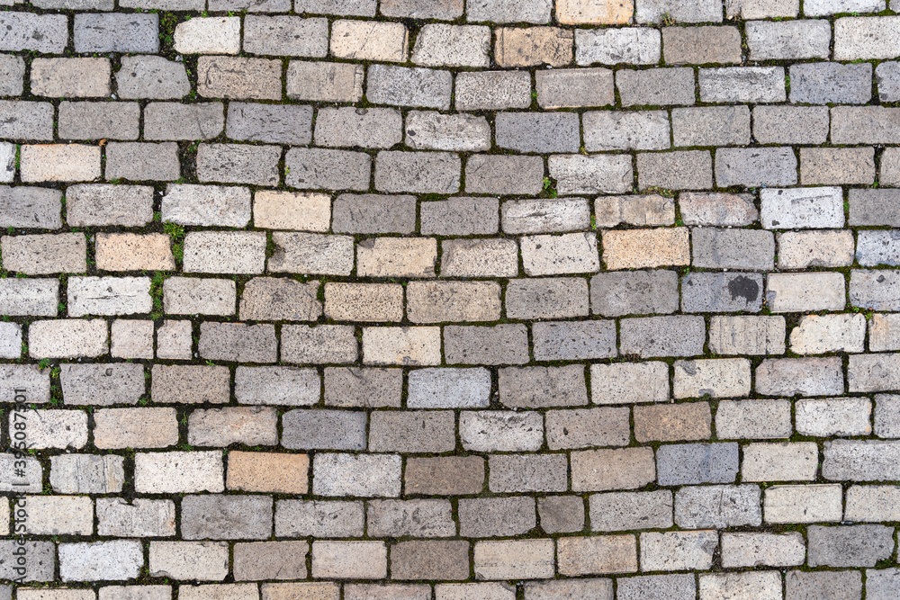 Stone cobble pattern on a street or pavement, grey granite material texture