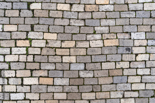 Stone cobble pattern on a street or pavement, grey granite material texture