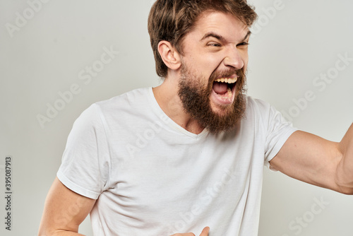 man in white t-shirt emotions expressions gesture with hands cropped view light background