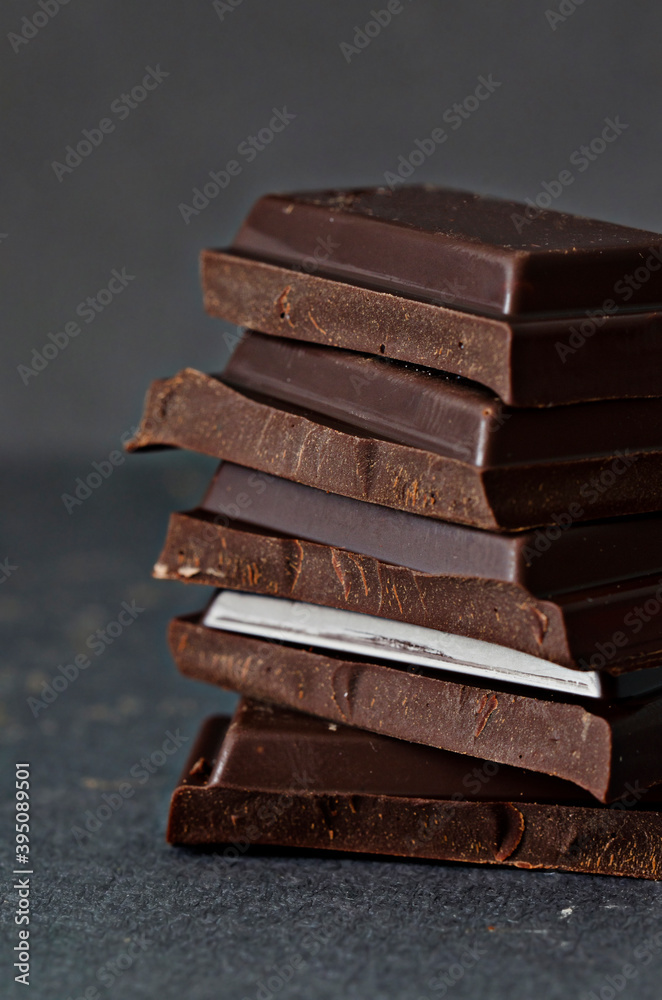 Five brown chocolate squares stacked in diagonal in a tower Five brown chocolate squares stacked in diagonal in a tower