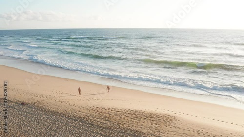 Two naked guys on beach, naturist zone, ocean photo