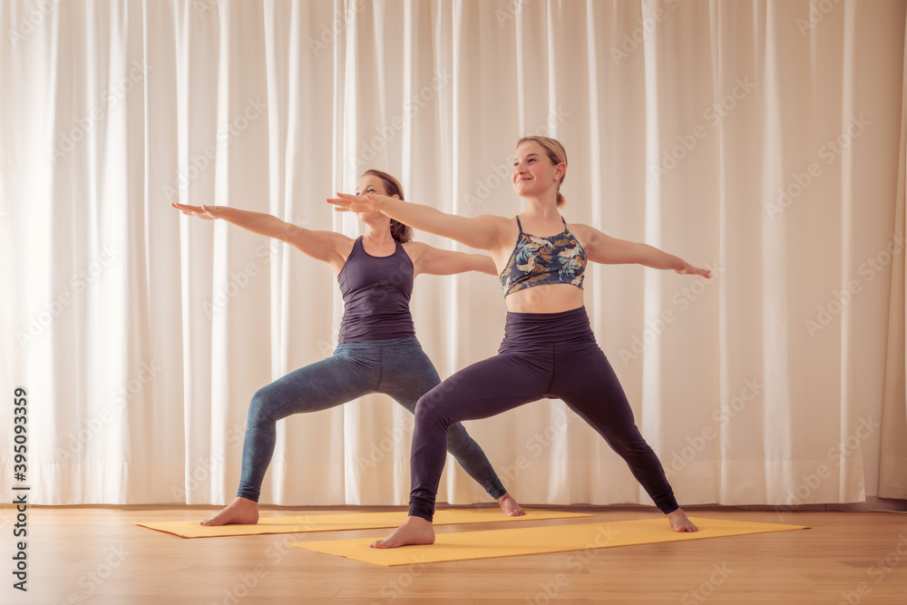 two women doing yoga at home two women doing yoga at home