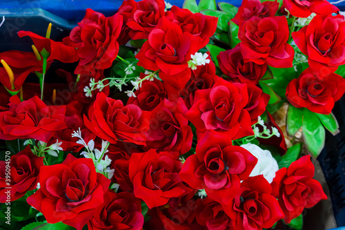 Decorative colorful artificial flowers are displayed for selling.