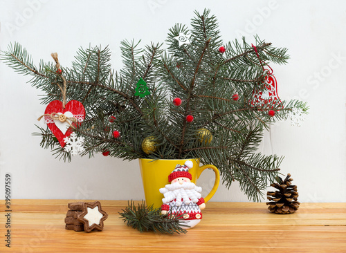 christmas composition of fir branches and feastday decor in a yellow cup photo