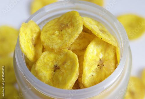A jar full of dried banana chips a delicacy of South Indian states Healthy sweet snack, crispy dehydrated unsweetened banana chips in colorful glass jar