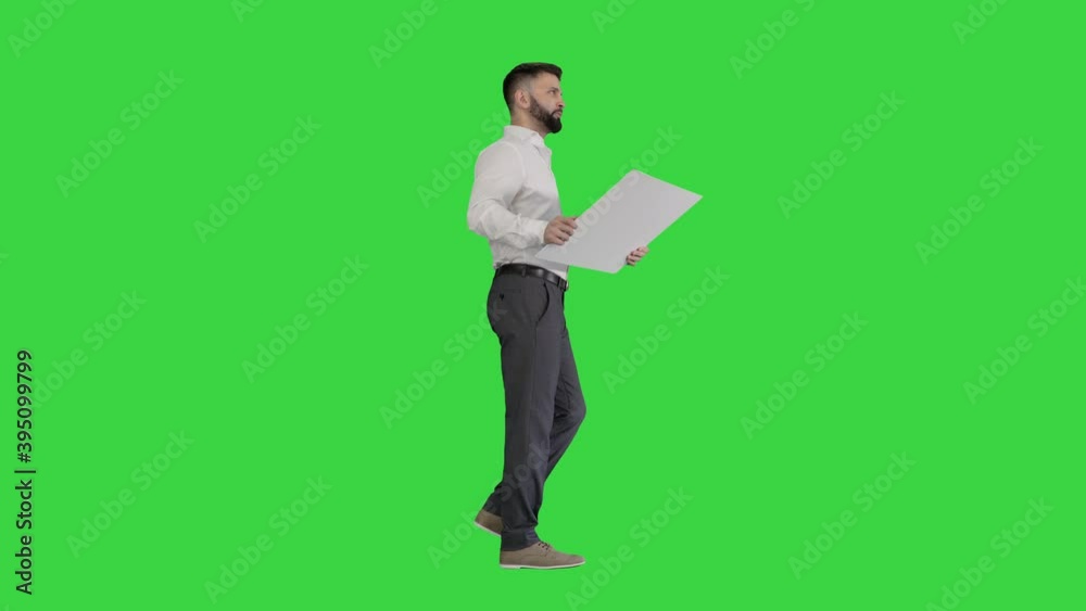 Business man walking and looking at blueprint on a Green Screen, Chroma Key. Business man walking and looking at blueprint on a Green Screen, Chroma Key.