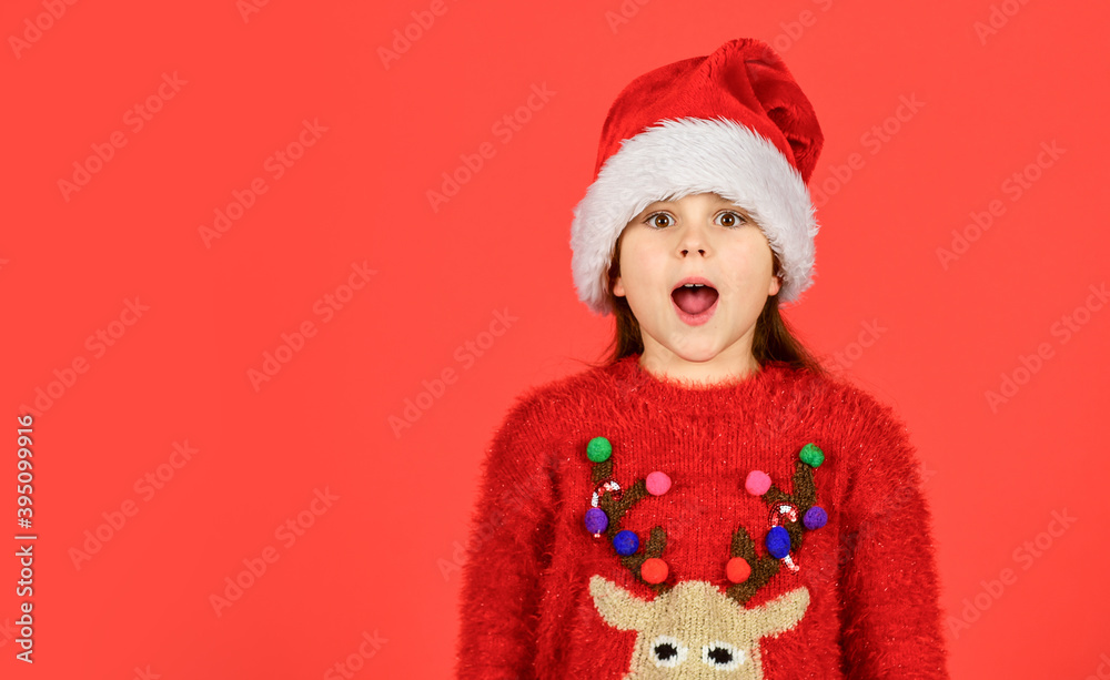 Emotional face expression. Happy childhood. Counting days till christmas. Christmas party. Can not hold back emotions. Christmas holiday invitation. Adorable girl wear santa claus hat red background Emotional face expression. Happy childhood. Counting days till christmas. Christmas party. Can not hold back emotions. Christmas holiday invitation. Adorable girl wear santa claus hat red background
