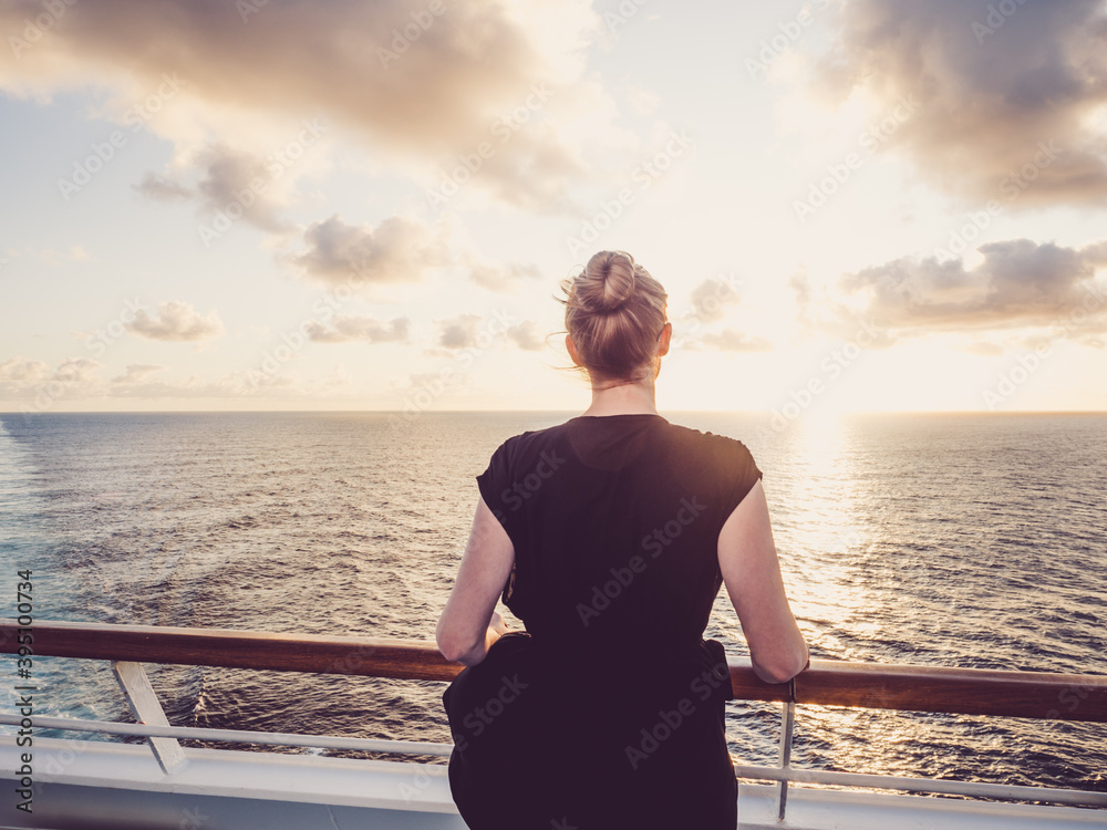 Fashionable woman on the empty deck of a cruise liner against a background of sea waves. Side view, close-up. Concept of leisure and travel