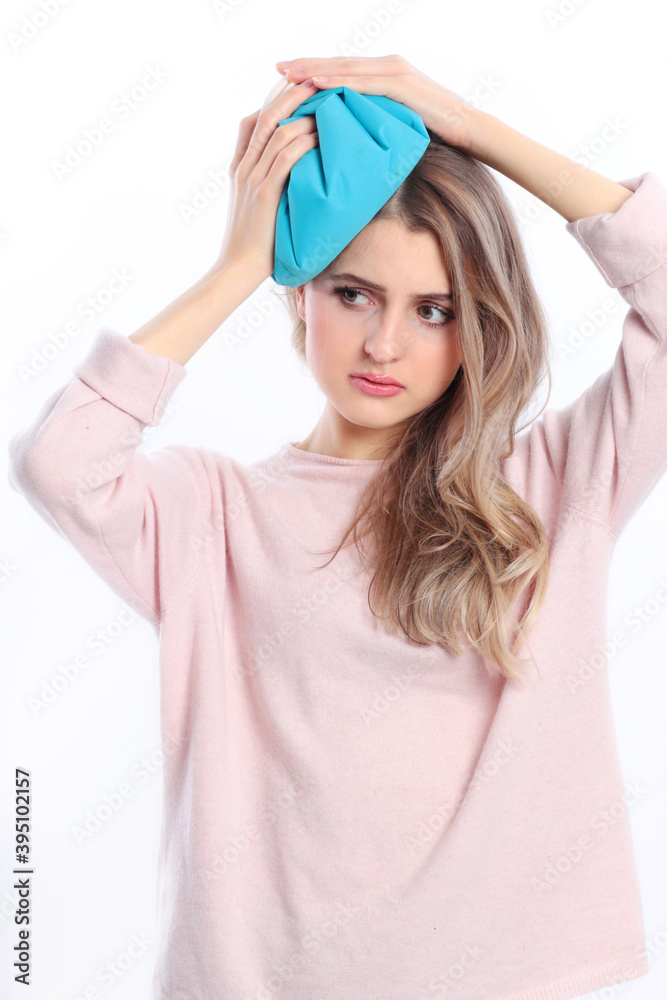 Woman holds icepack against her forehead isolated