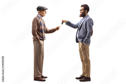 Bearded man giving car keys to an elderly man