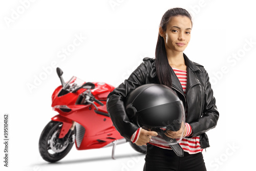 Young female motorcyclist with a ride bike holding a helmet
