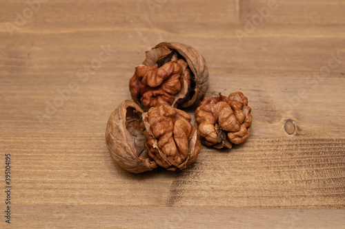 Tasty brown walnuts on wood background. Opened and not disclosed