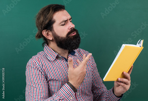 reading the poem. poetic man with beard reading the book. process of studying. nonformal education. male student in school classroom on literature lesson. pass the exam. learning the subject photo