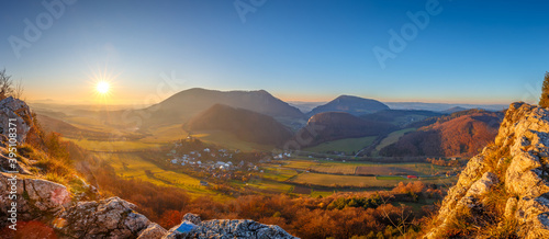 Mountainous landscape in autumn at sunset. Panoramic view from the top of the Bosmany rocky hill above the Kostolec village in northwestern Slovakia, Europe.