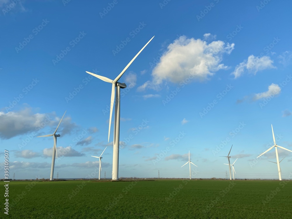 Wind farm turbines that produce electricity energy. Windmill Wind power technology productions Wind turbines standing in green field - stock footage Wind farm turbines that produce electricity energy. Windmill Wind power technology productions Wind turbines standing in green field - stock footage