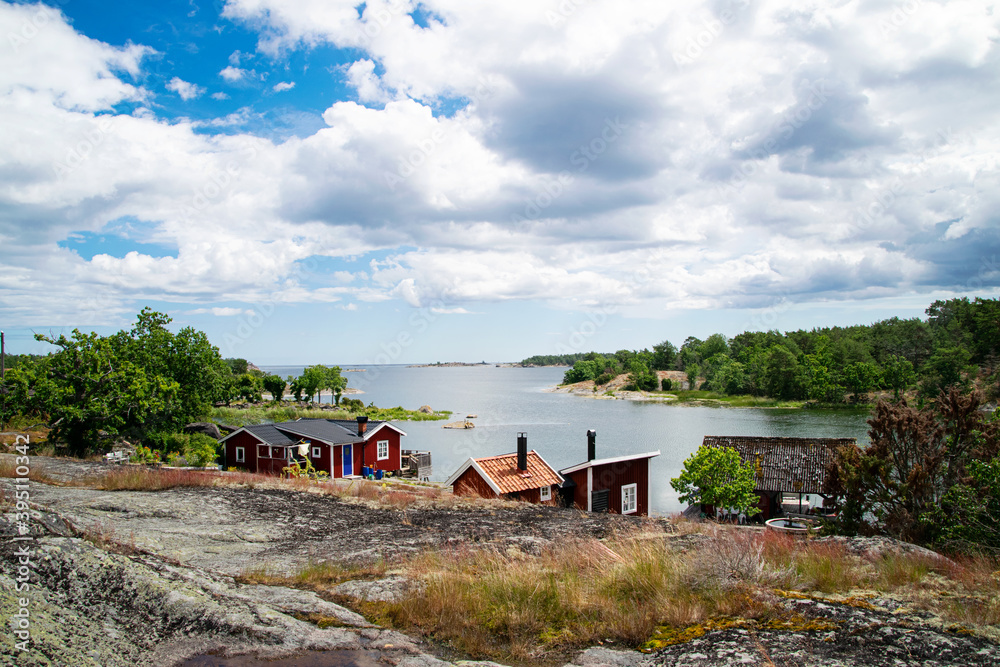Beautiful summer day in the archipelago. A very picturesque view with red summer holiday houses next to the sea on the island. Photo taken in Sweden.