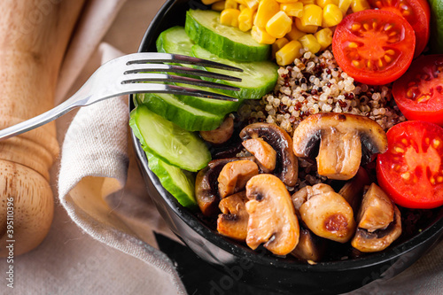 bowl of healthy quinoa with vegetables on a dark rustic background