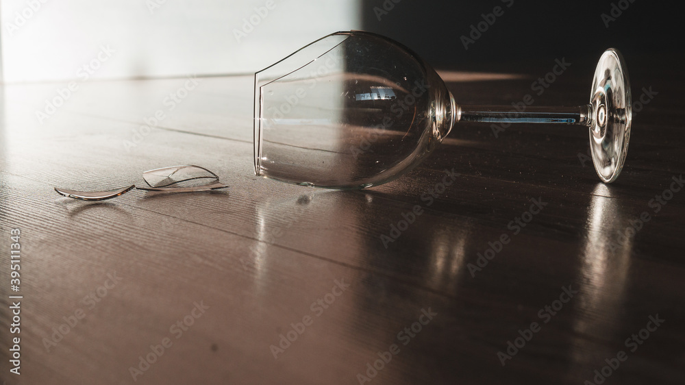 Broken wine glass goblet on the wooden floor