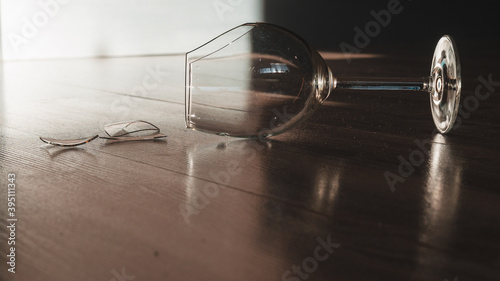Broken wine glass goblet on the wooden floor