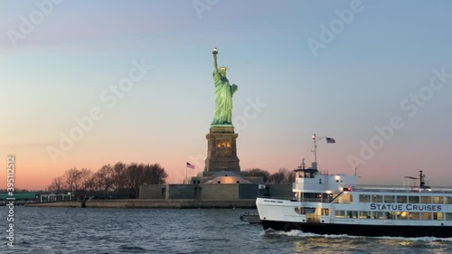 Statue Cruises ferry at sunset with the Statue of Liberty in the back