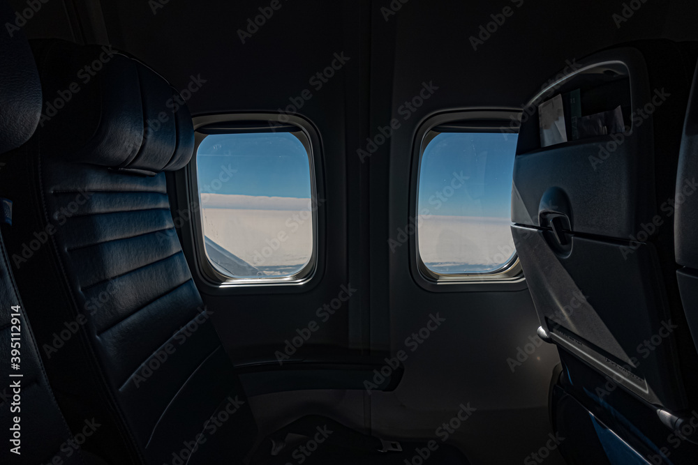 Blue Sky and clouds through two airplane windows.