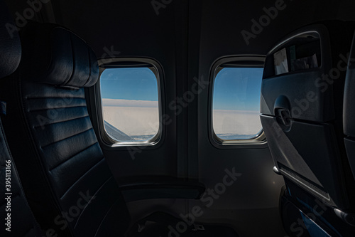 Blue Sky and clouds through two airplane windows.