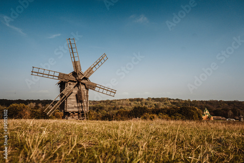 old wooden windmills stand in a field near the forest 1