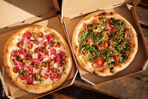 Two Italian pizzas in cardboard boxes. Italian fast food delivery.
