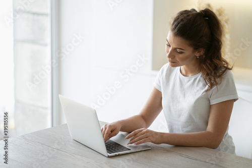 A woman is engaged in online shopping in the website app on a laptop computer gadget, shopping home for food products from a store near her home. Copy space