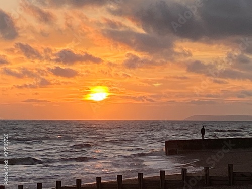 Hastings beach waves and seafront at sunset one man silhouette on concrete pier