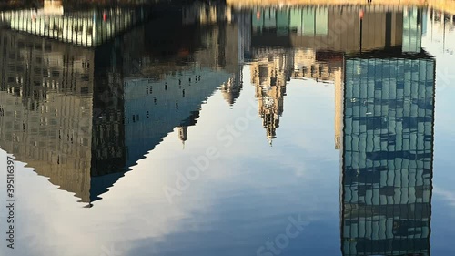 The Liver Building surrounded by modern office buildings and reflected in the gently rippling water of Canning Dock on a sunny day photo